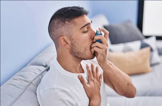 Man using an asthma inhaler.