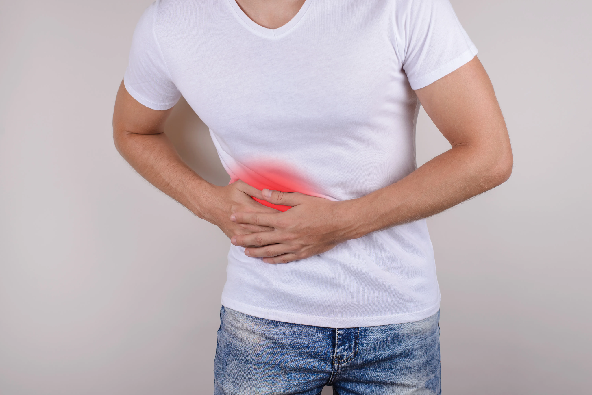 A man holding his lower right abdomen and side, with a red glow highlighting the location of pain.